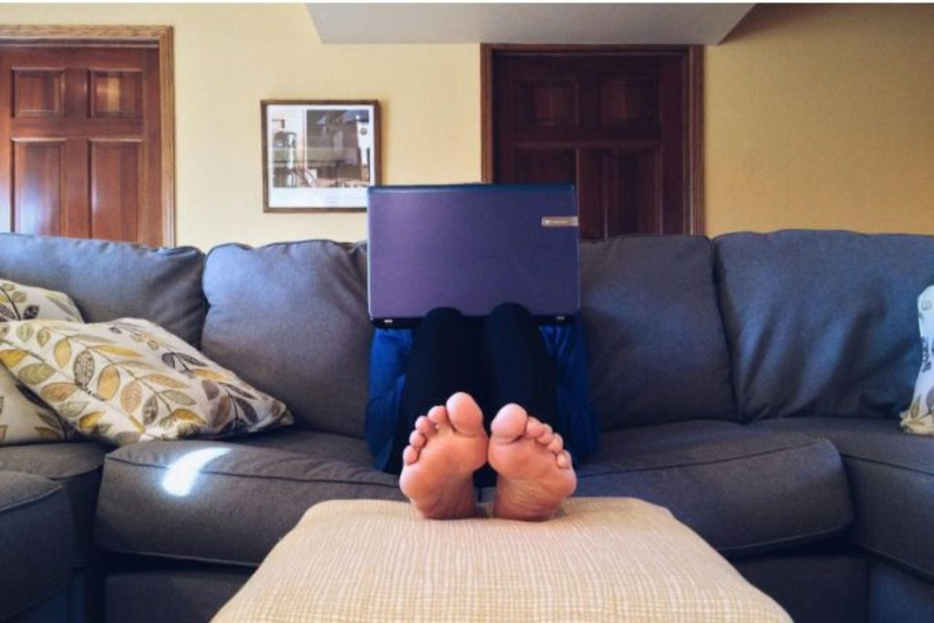 person sitting on a couch with feet on an ottoman