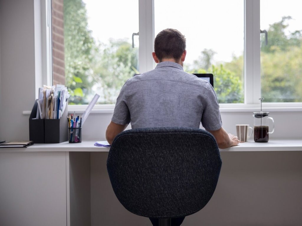 man sitting at desk working on laptop