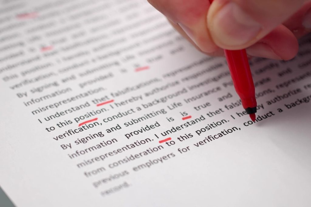person proofreading with a pen