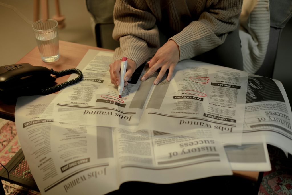 person looking at the job listings in a magazine