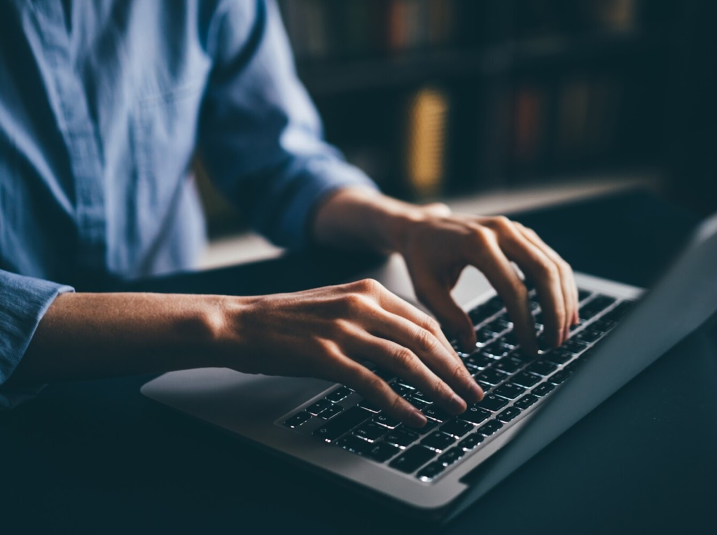 person typing on a laptop keyboard