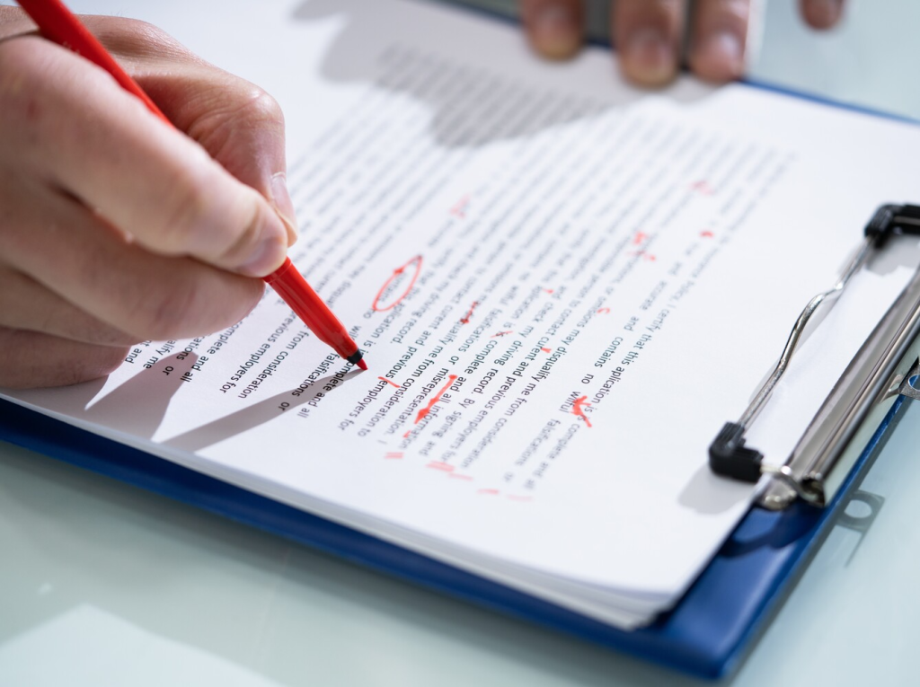 proofreading and editing a document with a red pen